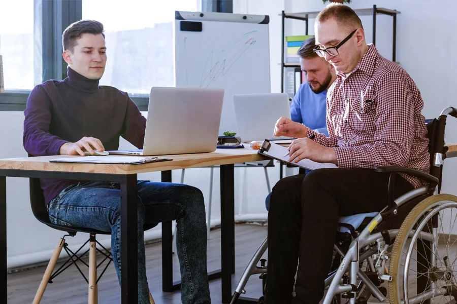 Picture of people (one in a wheelchair) working in an office, in the contact us section